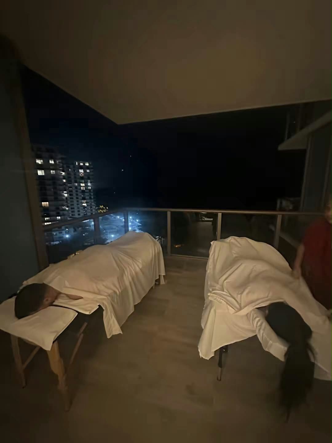 Couples massage on a Miami high-rise balcony at night, two tables side by side
